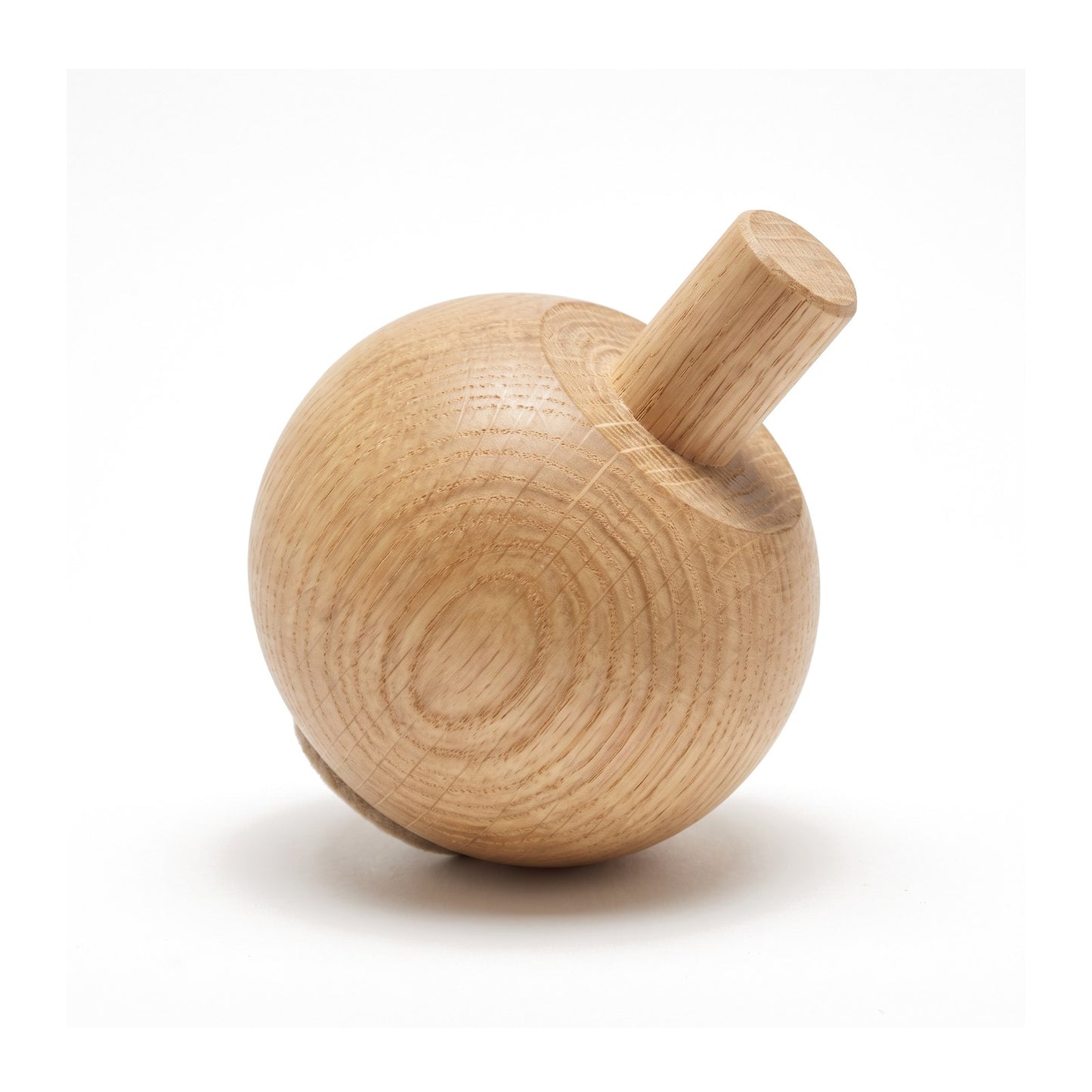 Close detail of a solid oak Bordesley ball foot on white, tipped to show the integral 20mm turned dowel spigot and unbroken grain