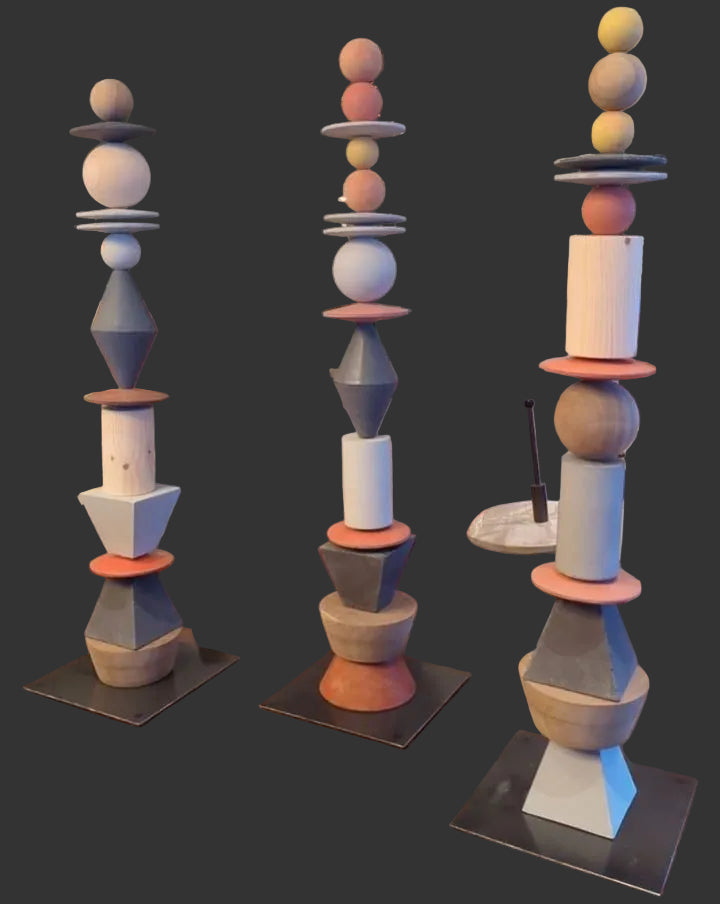 Decorative sculptures with geometric designs on a wooden surface, surrounded by indoor plants and furniture.