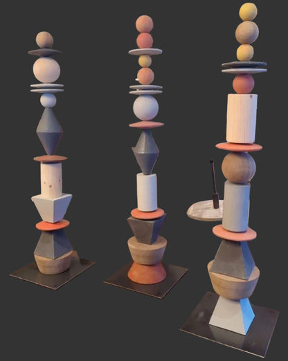 Decorative sculptures with geometric designs on a wooden surface, surrounded by indoor plants and furniture.