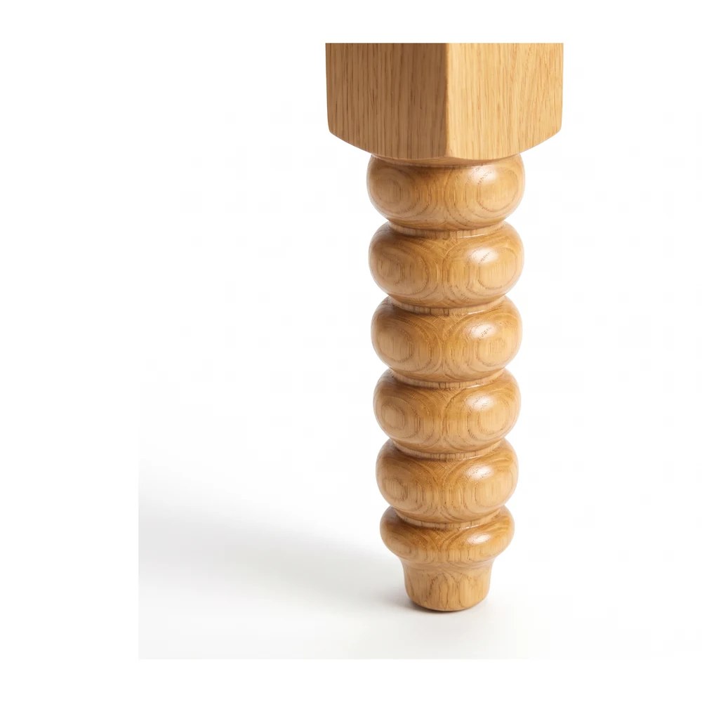 Close three-quarter detail of the bobbin bead run in oak on a white background