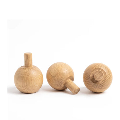Three oak ball feet on a white background showing the integral 20mm turned dowel spigot upright, in profile and from above