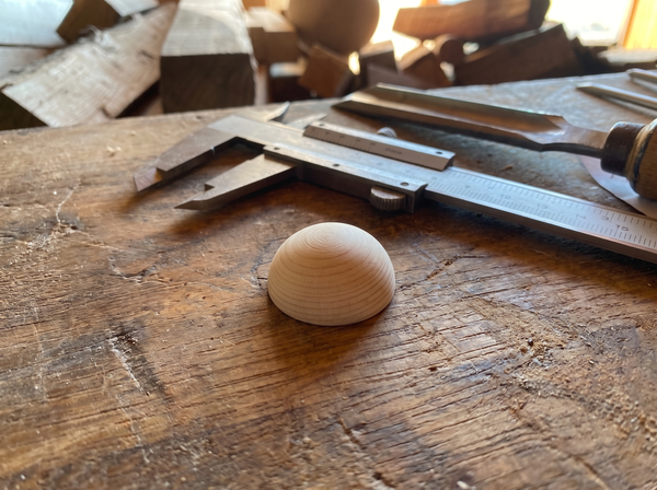 2 cm pine wooden hemisphere, hand-turned, on the workshop bench