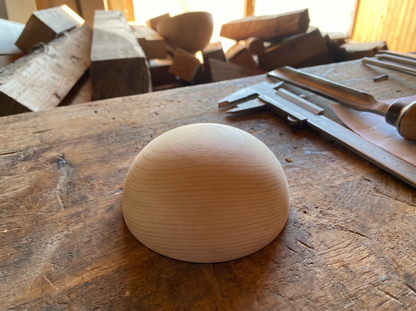 10 cm pine wooden hemisphere, hand-turned, on the workshop bench