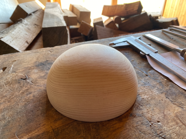 13 cm pine wooden hemisphere, hand-turned, on the workshop bench