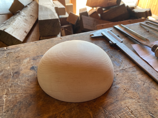 15 cm pine wooden hemisphere, hand-turned, on the workshop bench