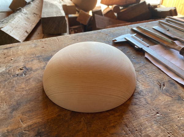 16 cm pine wooden hemisphere, hand-turned, on the workshop bench