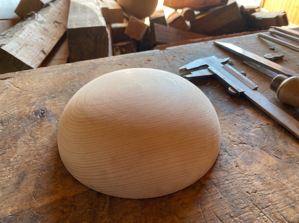 18 cm pine wooden hemisphere, hand-turned, on the workshop bench
