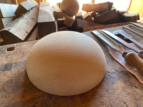 25 cm pine wooden hemisphere, hand-turned, on the workshop bench